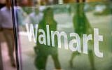 The Walmart logo displayed in the window of a Walmart Neighborhood Market store in Chicago, Illinois, August 15, 2013. (AFP Photo/Getty Images North America/Scott Olson)