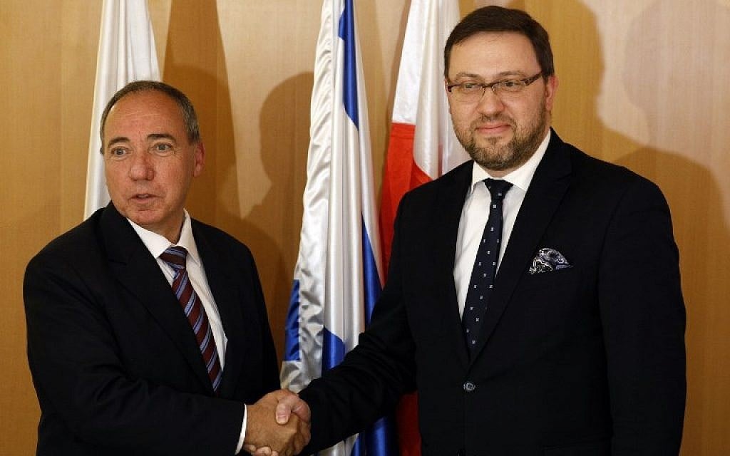 Foreign Ministry Director-General Yuval Rotem (L) shakes hands with Polish Deputy Foreign Minister Bartosz Cichocki during a meeting at the Foreign Ministry in Jerusalem on March 1, 2018, regarding the Polish Holocaust law. (AFP Photo/Gali Tibbon)