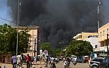 People watch as black smoke rises as the capital of Burkina Faso came under multiple attacks on March 2, 2018, targeting the French embassy, the French cultural center and the country's military headquarters. (AFP/Ahmed Ouoba)