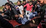Palestinians help evacuate an injured protester on a stretcher during clashes with Israeli troops near Khan Yunis by the border between Israel and the southern Gaza strip on March 2, 2018. (AFP PHOTO / SAID KHATIB)