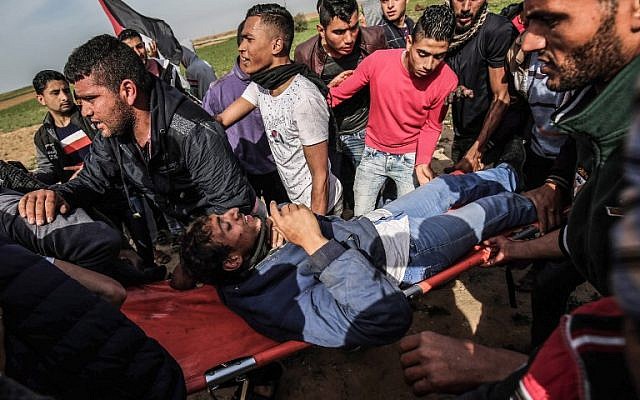 Palestinians help evacuate an injured protester on a stretcher during clashes with Israeli troops near Khan Yunis by the border between Israel and the southern Gaza strip on March 2, 2018. (AFP PHOTO / SAID KHATIB) Palestinians help evacuate an injured protester on a stretcher during clashes with Israeli troops near Khan Yunis by the border between Israel and the southern Gaza strip on March 2, 2018. (AFP PHOTO / SAID KHATIB)