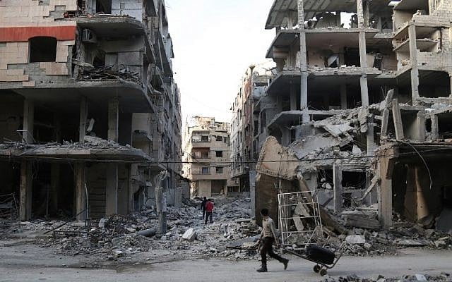 A Syrian youth pulls a cart as he walks down a street past destroyed buildings in the rebel-held besieged town of Ayn Tarma in the eastern Ghouta region on the outskirts of the capital Damascus on March 2, 2018. (AFP PHOTO / Ammar SULEIMAN) A Syrian youth pulls a cart as he walks down a street past destroyed buildings in the rebel-held besieged town of Ayn Tarma in the eastern Ghouta region on the outskirts of the capital Damascus on March 2, 2018. (AFP PHOTO / Ammar SULEIMAN)
