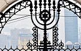 This photograph taken on February 23, 2018, shows a gate at the entrance of The Jewish Cemetery with the background of the city center of Sarajevo. (AFP PHOTO / ELVIS BARUKCIC)