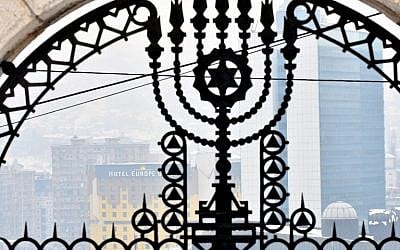 This photograph taken on February 23, 2018, shows a gate at the entrance of The Jewish Cemetery with the background of the city center of Sarajevo. (AFP PHOTO / ELVIS BARUKCIC)