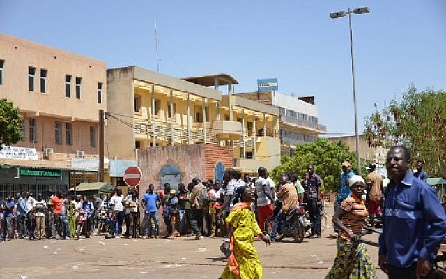 Bystanders watch the scene outside the headquarters of the country's defense forces in Ouagadougou on March 2, 2018 after dozens of people were killed in twin attacks on the French embassy and the country's military. (AFP PHOTO / Ahmed OUOBA) Bystanders watch the scene outside the headquarters of the country's defense forces in Ouagadougou on March 2, 2018 after dozens of people were killed in twin attacks on the French embassy and the country's military. (AFP PHOTO / Ahmed OUOBA)