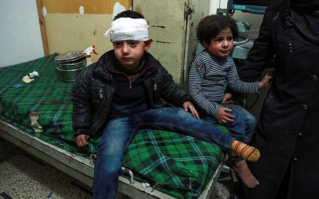 A bandaged Syrian child sits on a bed next to another child after receiving medical attention at a makeshift hospital in the rebel-held town of Douma, in the besieged Eastern Ghouta region on the outskirts of the capital Damascus, following reported regime bombardment on March 3, 2018. / AFP PHOTO / HAMZA AL-AJWEH A bandaged Syrian child sits on a bed next to another child after receiving medical attention at a makeshift hospital in the rebel-held town of Douma, in the besieged Eastern Ghouta region on the outskirts of the capital Damascus, following reported regime bombardment on March 3, 2018. / AFP PHOTO / HAMZA AL-AJWEH