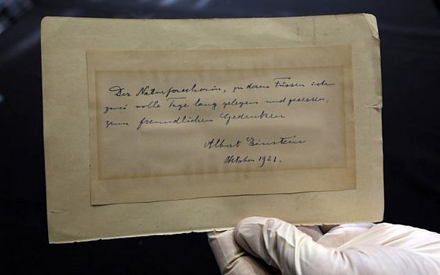 A picture taken on March 6, 2018 in Jerusalem shows Winner's auction house owner and manager Gal Wiener holding up a letter written by Nobel Prize-winning physicist Albert Einstein to Italian chemist Elisabetta Piccini, dated 1921, prior to its auctioning later in the night with the rest of a series of nine. (AFP PHOTO / MENAHEM KAHANA) A picture taken on March 6, 2018 in Jerusalem shows Winner's auction house owner and manager Gal Wiener holding up a letter written by Nobel Prize-winning physicist Albert Einstein to Italian chemist Elisabetta Piccini, dated 1921, prior to its auctioning later in the night with the rest of a series of nine. (AFP PHOTO / MENAHEM KAHANA)