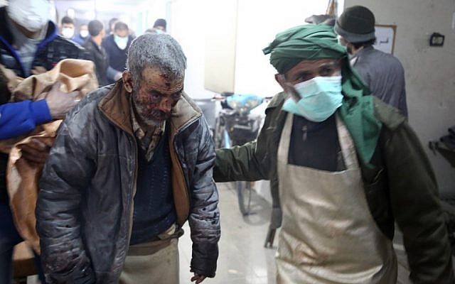 A wounded Syrian man is brought into a clinic in Syria's Eastern Ghouta on March 7, 2018, after regime air strikes. (AFP PHOTO / Amer ALMOHIBANY)