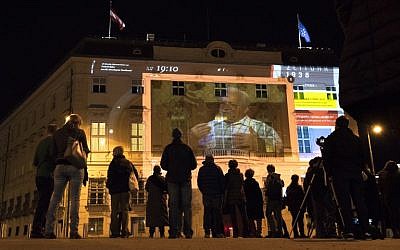 People watch 'Zeituhr 1938', a projection on the facade of the Austrian Chancellery that retraces the dark moments leading to the Nazi takeover by Adolf Hitler in 1938, one day ahead of the 80th anniversary of Austria's annexation ("Anschluss"), on March 11, 2018 in Vienna, Austria. (AFP PHOTO / JOE KLAMAR)