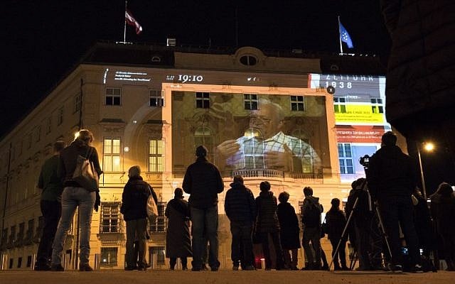 People watch 'Zeituhr 1938', a projection on the facade of the Austrian Chancellery that retraces the dark moments leading to the Nazi takeover by Adolf Hitler in 1938, one day ahead of the 80th anniversary of Austria's annexation ("Anschluss"), on March 11, 2018 in Vienna, Austria. (AFP PHOTO / JOE KLAMAR)