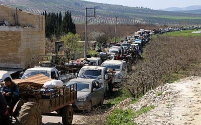Syrian civilians ride their cars through Ain Dara in Syria's northern Afrin region, as they flee the city of Afrin on March 12, 2018, amid battles between Turkish-backed forces and Kurdish fighters. (AFP PHOTO / STRINGER)
