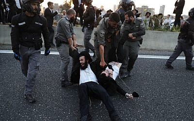 Illustrative: Police remove ultra-Orthodox demonstrators who are blocking a road during a protest against army conscription in the city of Bnei Brak, near Tel Aviv, on March 12, 2018. (AFP Photo/Ahmad Gharabli)