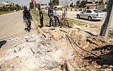 Members of the Hamas security forces inspect the crater left at the site of an explosion that targeted the convoy of the Palestinian Prime Minister during his visit to the Gaza strip on March 13, 2018. (AFP/ MAHMUD HAMS)