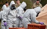 British military personnel wearing protective coveralls work to remove a vehicle connected to the March 4 nerve agent attack in Salisbury, from a residential street in Gillingham, southeast England, on March 14, 2018. (AFP Photo/Adrian Dennis)