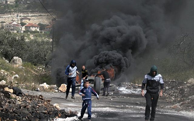 Palestinians burn tires during clashes with Israeli soldiers in the northern West Bank village of Kfar Qaddum on March 16, 2018. (AFP Photo/Jaafar Ashtiyeh) Palestinians burn tires during clashes with Israeli soldiers in the northern West Bank village of Kfar Qaddum on March 16, 2018. (AFP Photo/Jaafar Ashtiyeh)