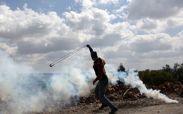A young Palestinian protester prepares to fire a slingshot during clashes with Israeli soldiers in the village of Kfar Qaddum, near Nablus, in the West Bank, on March 16, 2018. (AFP PHOTO / JAAFAR ASHTIYEH) A young Palestinian protester prepares to fire a slingshot during clashes with Israeli soldiers in the village of Kfar Qaddum, near Nablus, in the West Bank, on March 16, 2018. (AFP PHOTO / JAAFAR ASHTIYEH)