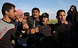 Palestinian men evacuate an injured protester during clashes with Israeli troops along the border fence near Khan Yunis in the southern Gaza Strip on March 16, 2018. (AFP Photo/Said Khatib)