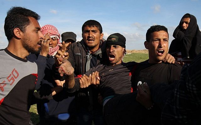 Palestinian men evacuate an injured protester during clashes with Israeli troops along the border fence near Khan Yunis in the southern Gaza Strip on March 16, 2018. (AFP Photo/Said Khatib) Palestinian men evacuate an injured protester during clashes with Israeli troops along the border fence near Khan Yunis in the southern Gaza Strip on March 16, 2018. (AFP Photo/Said Khatib)