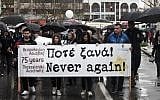 Illustrative: People hold a banner as they walk towards the old railway station in Thessaloniki during a commemoration marking the departure of the first train from the northern Greek city to the Auschwitz concentration camp in Poland, held on March 18, 2018. (SAKIS MITROLIDIS/AFP)