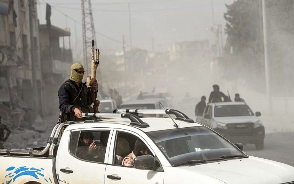 File: Turkish-backed Syrian Arab fighters stand in the back of a vehicle after seizing control of the northwestern Syrian city of Afrin from the Kurdish People's Protection Units (YPG) on March 18, 2018. (AFP PHOTO / BULENT KILIC) File: Turkish-backed Syrian Arab fighters stand in the back of a vehicle after seizing control of the northwestern Syrian city of Afrin from the Kurdish People's Protection Units (YPG) on March 18, 2018. (AFP PHOTO / BULENT KILIC)