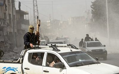 File: Turkish-backed Syrian Arab fighters stand in the back of a vehicle after seizing control of the northwestern Syrian city of Afrin from the Kurdish People's Protection Units (YPG) on March 18, 2018. (AFP PHOTO / BULENT KILIC)