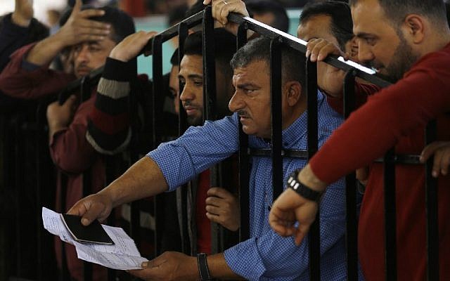 Palestinians wait for travel permits to cross into Egypt through the Rafah border crossing after it was opened by Egyptian authorities for humanitarian cases, in Khan Yunis in the southern Gaza Strip on March 23, 2018. (AFP/Mohammed Abed)