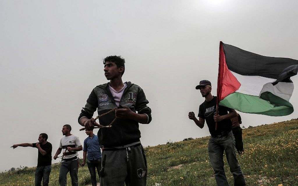 A Palestinian demonstrator hurls stones at Israeli troops during clashes near the border with Israel at Khan Yunis in the southern Gaza Strip, March 23, 2018. (AFP PHOTO / SAID KHATIB)