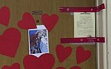This AFP TV video frame grab shows a picture of Mireille Knoll, heart-shaped papers and police seals posted on the door of her apartment in Paris, March 27, 2018. (Laetitia PERON)