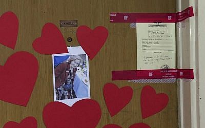 This AFP TV video frame grab shows a picture of Mireille Knoll, heart-shaped papers and police seals posted on the door of her apartment in Paris, March 27, 2018. (Laetitia PERON)