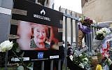 A photograph of murdered Holocaust survivor Mireille Knoll is placed along with flowers on the fence surrounding her building in Paris on March 28, 2018. (Francois Guillot/AFP)