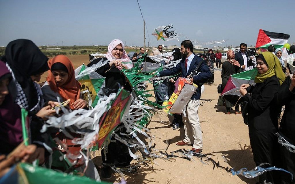 Palestinian women fly kites marked with the colors of the Palestinian flag during a demonstration ahead of the Land Day, at a tent city along the border with Israel east of Gaza City on March 29, 2018.(AFP PHOTO / MOHAMMED ABED)