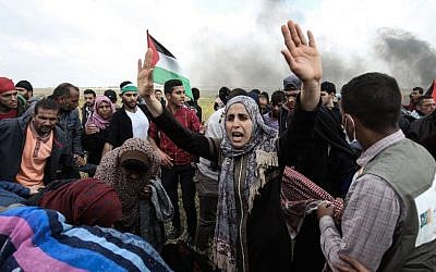 Palestinian protestors wave their national flag during a demonstration near the border with Israel, east of Gaza City, on March 30, 2018. (AFP PHOTO / MAHMUD HAMS)