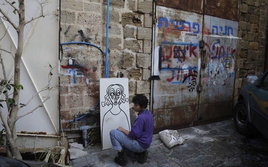 Israeli-born New York-based street artist Sara Erenthal draws one of her emblematic woman's faces in Tel Aviv on January 28, 2018. (AFP Photo/Menahem Kahana)