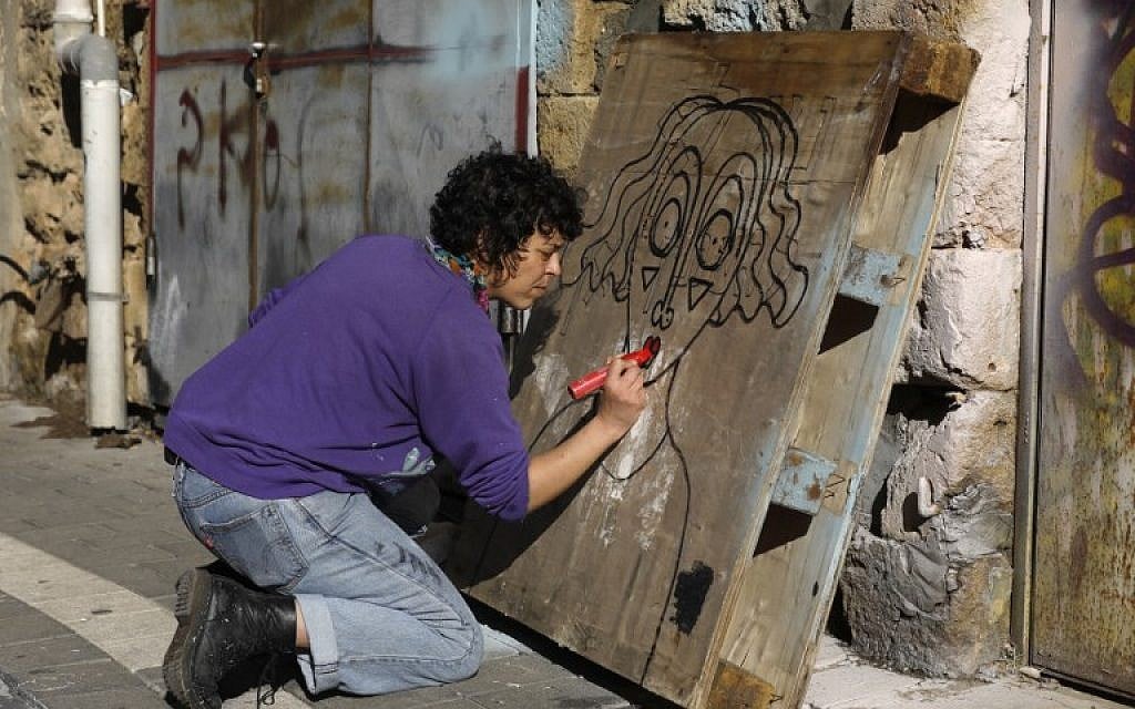 New York-based Israeli-born street artist Sara Erenthal draws one of her emblematic woman's face in the Israeli coastal city of Tel Aviv on January 28, 2018.
With her nose piercing, jeans and sweatshirt, rising street artist Sara Erenthal looks nothing like what she was 20 years ago -- part of one of the most extreme ultra-Orthodox Jewish groups. The 36-year-old New York-based street artist who left religious life behind has gained growing attention for her unusual murals and art that gives a second life to found objects.
(AFP Photo/Menahem Kahana)
