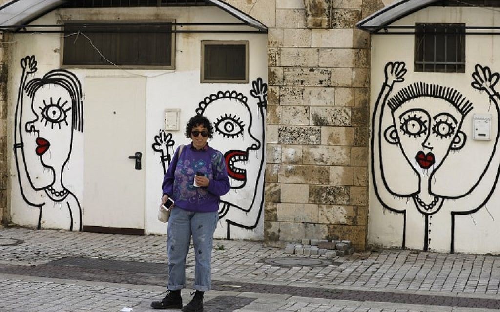 Israeli-born New York-based street artist Sara Erenthal stands in front of one of her murals in Tel Aviv on January 28, 2018. (AFP Photo/Menahem Kahana)