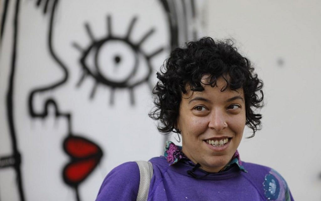 Israeli-born New York-based street artist Sara Erenthal smiles in front of one of her murals in Tel Aviv on January 28, 2018.
(AFP Photo/Menahem Kahana)