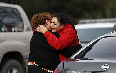 Vanessa Flores (R) embraces another woman after she leaves the locked down Veterans Home of California during an active shooter turned hostage situation on March 9, 2018, in Yountville, California. (Stephen Lam/Getty Images/AFP)