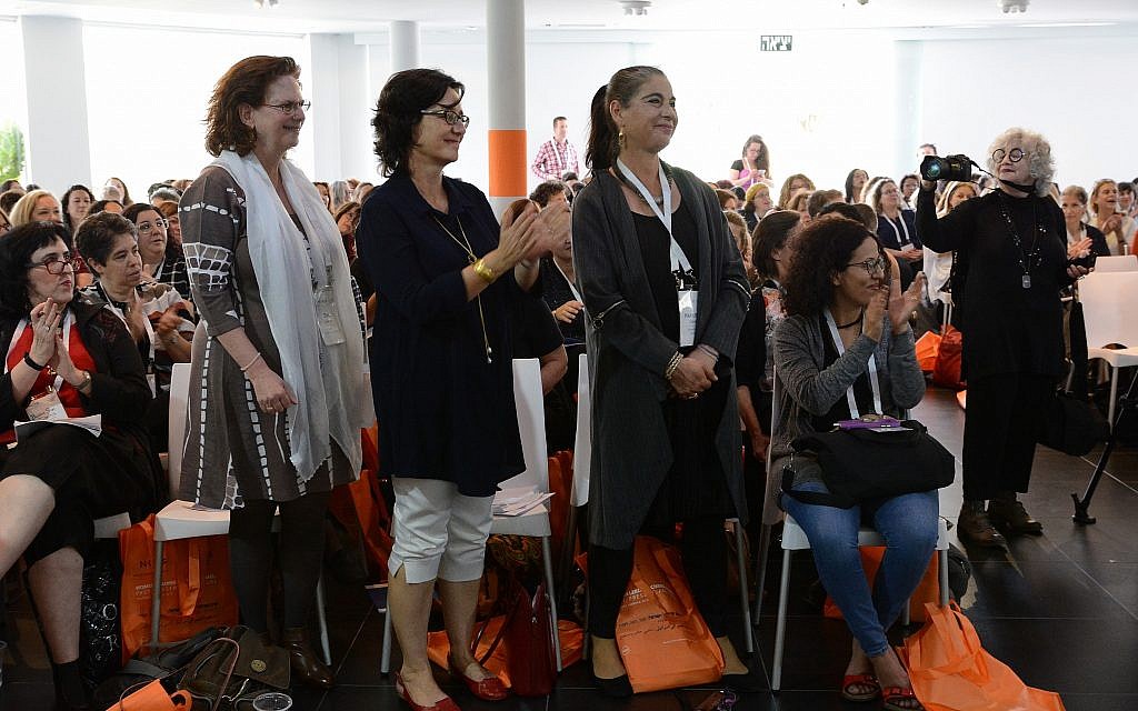 Hamutal Gouri, executive director of The Dafna Fund, and other attendees stand to cheer during the NCJW symposium's opening session. (Gal Mosenson)