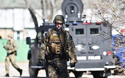 Law enforcement officers search a wooded area for a suspect involved in a shooting at a Central Michigan University residence hall on Friday, March 2, 2018 in Mt. Pleasant, Mich.  (Matthew Dae Smith/Lansing State Journal via AP)