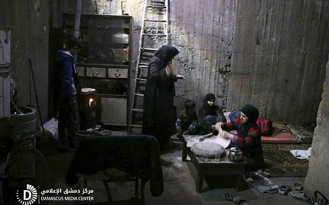 Syrians living in a shelter seeking protection from airstrikes and shelling by Syrian government forces, in Ghouta, a suburb of Damascus, Syria, released on February 21, 2018. (Syrian anti-government activist group Damascus Media Center via AP) Syrians living in a shelter seeking protection from airstrikes and shelling by Syrian government forces, in Ghouta, a suburb of Damascus, Syria, released on February 21, 2018. (Syrian anti-government activist group Damascus Media Center via AP)