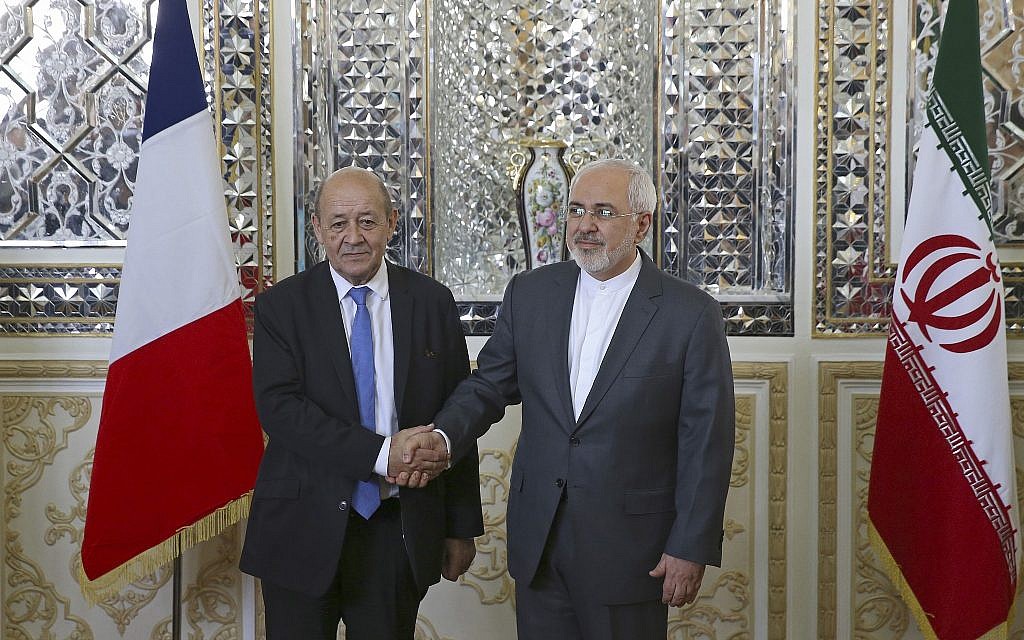 Iranian Foreign Minister Mohammad Javad Zarif, right, and his French counterpart Jean-Yves Le Drian, shake hands for journalists at the start of their meeting in Tehran, Iran, on March 5, 2018. (AP Photo/Vahid Salemi)