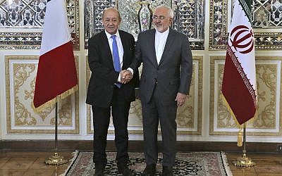 Iranian Foreign Minister Mohammad Javad Zarif, right, and his French counterpart Jean-Yves Le Drian, shake hands for journalists at the start of their meeting in Tehran, Iran on, March 5, 2018. (AP Photo/Vahid Salemi)