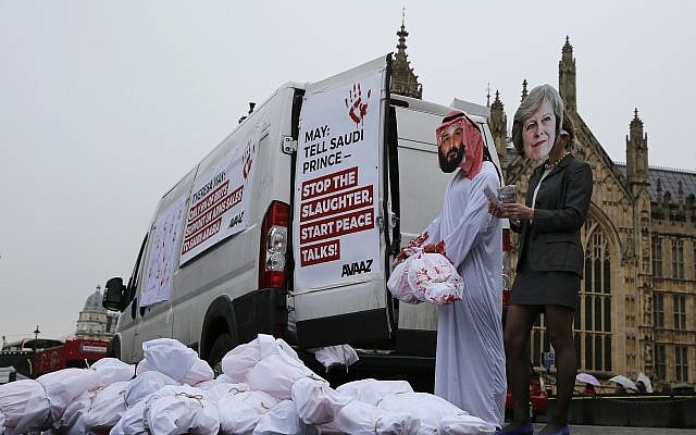 Two protesters wear masks with photographs of Britain's Prime Minister Theresa May and Saudi Crown Prince Mohammad bin Salman outside the Palace of Westminster in London, March 7, 2018. (AP Photo/Alastair Grant) Two protesters wear masks with photographs of Britain's Prime Minister Theresa May and Saudi Crown Prince Mohammad bin Salman outside the Palace of Westminster in London, March 7, 2018. (AP Photo/Alastair Grant)