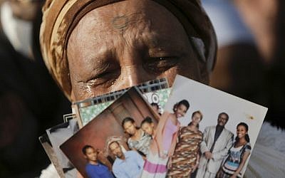 An Ethiopian Israeli woman holds pictures of relatives as she protests in front of the Knesset in Jerusalem, Monday, March 12, 2018. (AP Photo/Sebastian Scheiner)