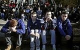 In this February 28, 2018, file photo, Somerville High School students sit on the sidewalk on Highland Avenue during a student walkout at the school in Somerville, Massachusetts. (Craig F. Walker/The Boston Globe via AP, File)