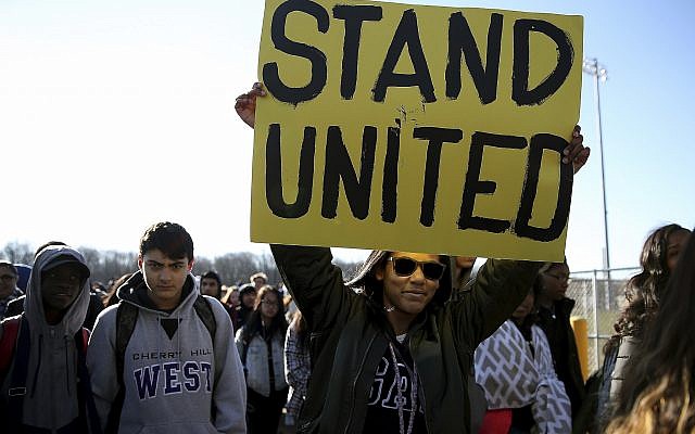 Freshman Kennedi Lawson, 14, carries a sign as student walkout at Cherry Hill West High School in remembrance of those killed in the Parkland, Florida, shooting in Cherry Hill, New Jersey, on March 14, 2018. (David Maialetti /The Philadelphia Inquirer via AP) Freshman Kennedi Lawson, 14, carries a sign as student walkout at Cherry Hill West High School in remembrance of those killed in the Parkland, Florida, shooting in Cherry Hill, New Jersey, on March 14, 2018. (David Maialetti /The Philadelphia Inquirer via AP)