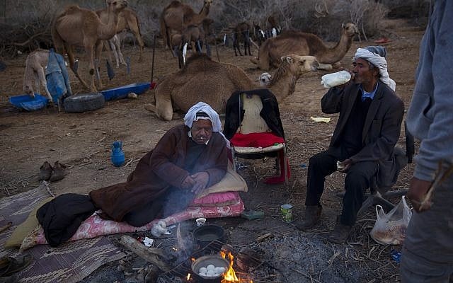 Beduin camel owner Ali El Guran, left, and his camel herder Salem Rashaideh, have their breakfast at their camp near Kibbutz Kalya, Dead Sea, February 10, 2018. (AP Photo/Oded Balilty) Beduin camel owner Ali El Guran, left, and his camel herder Salem Rashaideh, have their breakfast at their camp near Kibbutz Kalya, Dead Sea, February 10, 2018. (AP Photo/Oded Balilty)