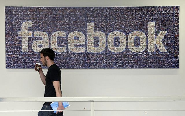 In this March 15, 2013, file photo, a Facebook employee walks past a sign at Facebook headquarters in Menlo Park, Calif. (AP Photo/Jeff Chiu) In this March 15, 2013, file photo, a Facebook employee walks past a sign at Facebook headquarters in Menlo Park, Calif. (AP Photo/Jeff Chiu)