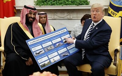 US President Donald Trump, right, shows a chart highlighting arms sales to Saudi Arabia during a meeting with Saudi Crown Prince Mohammed bin Salman in the Oval Office of the White House, in Washington, March 20, 2018. (AP Photo/Evan Vucci)