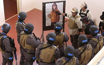 In this Sunday, March 18, 2018 photo, an instructor speaks to members of a Tunisian police commando unit during a drill at the Jordan Gendarmerie Training Academy, in al-Swaqa, about 44 miles (70 km) south of Amman, Jordan. (AP Photo/Raad Adayleh)